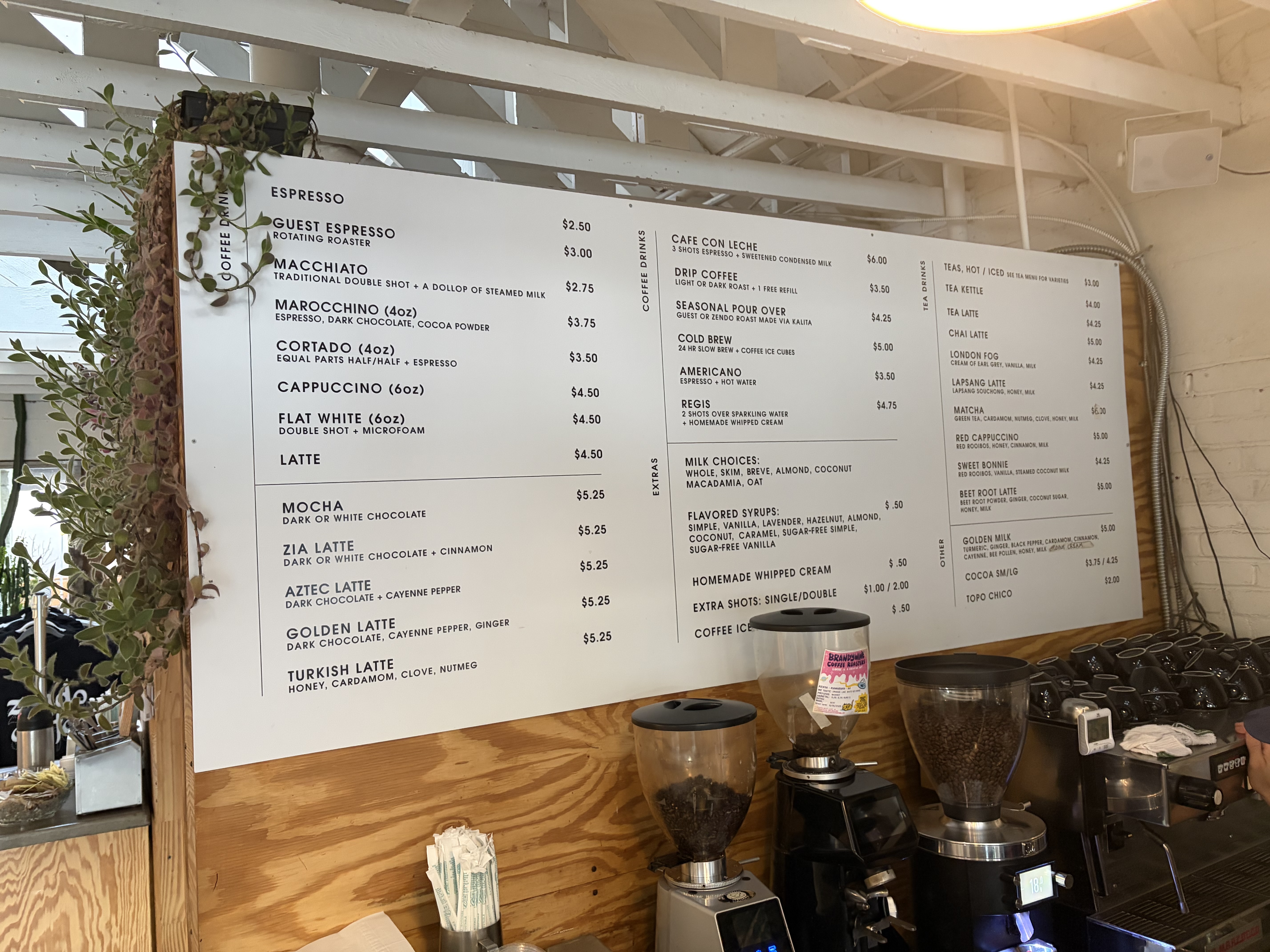 The espresso menu board: guest espresso 2.50, macchiato 3.00, marocchino 2.75, cortado 3.75, cappuccino 3.50, flat white 4.50, latte 4.50, and lattes including Zia, Aztec, Golden and Turkish at 5.25.