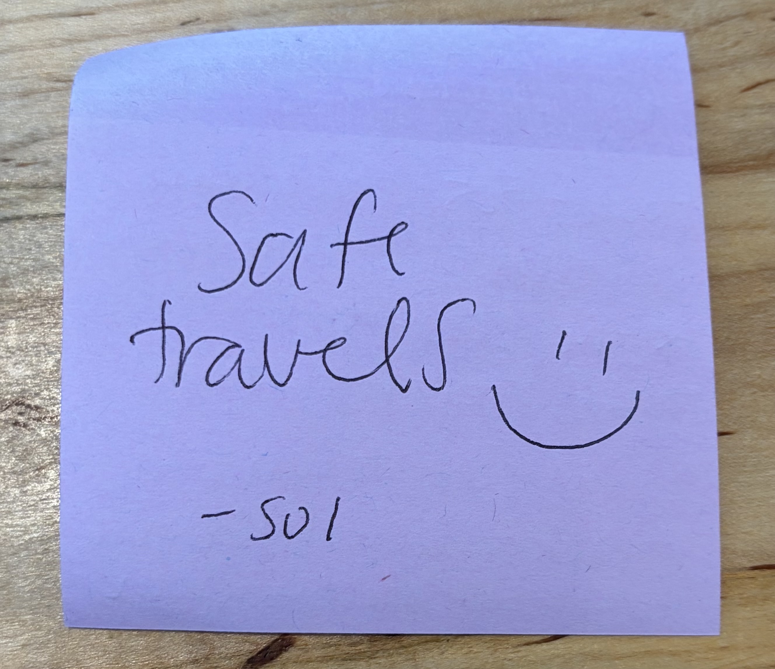 A second handwritten sticky note reading: Safe travels, with a smiley face, signed by the barista.